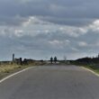 An older couple walking together along a quiet country road.