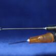 A syringe with a droplet of liquid at the tip of the needle.