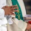 Altar servers kneeling during the Eucharistic celebration at Mass in Saint Agatha Church, Rumilly, France
