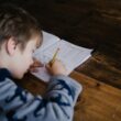 A young boy writing at a desk